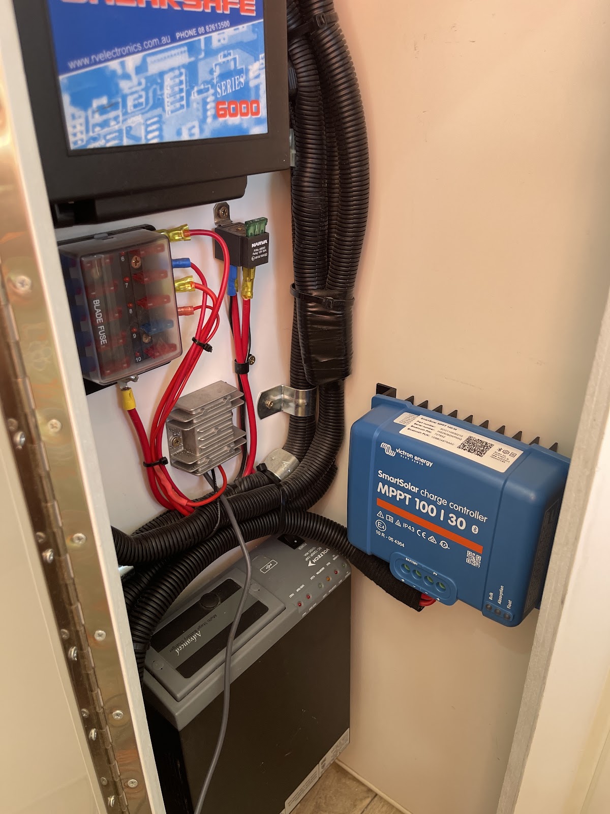 Solar charge controller and wiring fitted inside a caravan cupboard