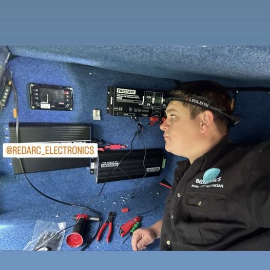 Josh in a Bellectrics shirt wiring gear inside a vehicle